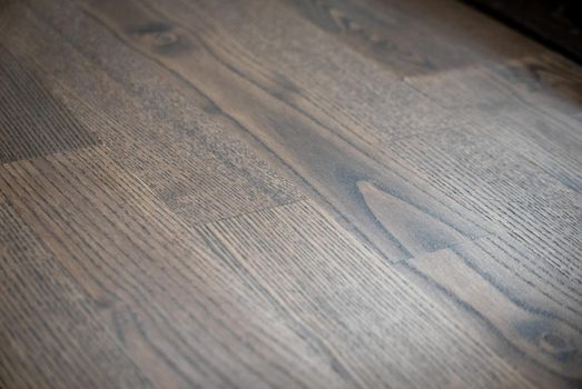 Dark brown wooden parquet floor texture as background.