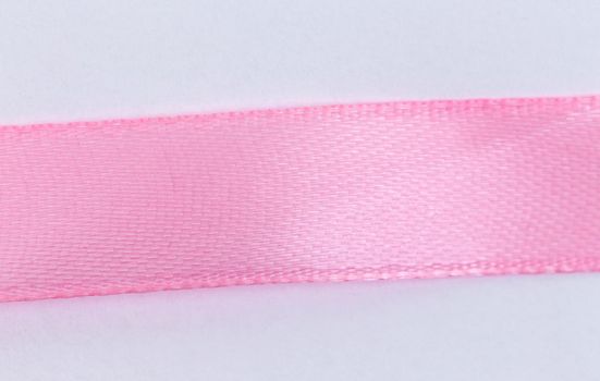 Closeup Pink ribbon on white background with copy space for text.