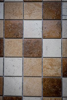 Brown ceramic mosaic on the wall as background.