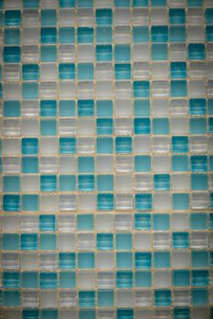 Light blue and white ceramic mosaic on the wall as background.