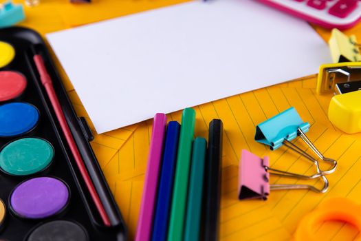 School office supplies stationery on a orange paper background with copy space. Back to school concept.