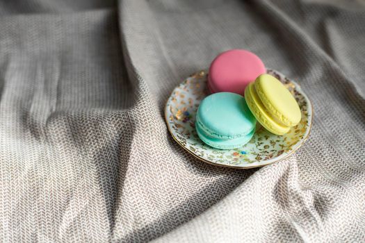 traditional french colorful macarons cookies stand on wooden table,pastel colors macaroons for afternoon tea or coffee copy space