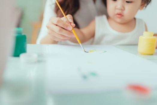 Mother and daughter have a fun painting with watercolor paints