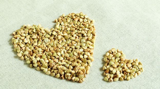 Heart made of green buckwheat. Symbol of love and health. Great food. healthy groats. Organic raw non-fried vegetarian food. The concept of a healthy, balanced and dietary diet. Copy space.