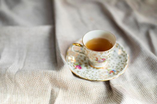 Porcelain tea pot and cup of hot tea on the table, antique traditional crockery set, high tea English afternoon tea cozy stylish interior