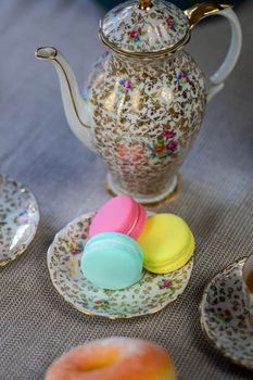 Traditional table with cup of tea and tea pot and colorful macaron lovely cozy table at home,Mother's Day tea setting with teapot, close up