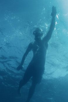 Active man swimming in the sea on vacations, bottom view.