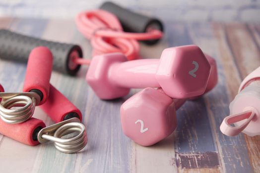 pink color dumbbell, shoe and headphone on pink background .
