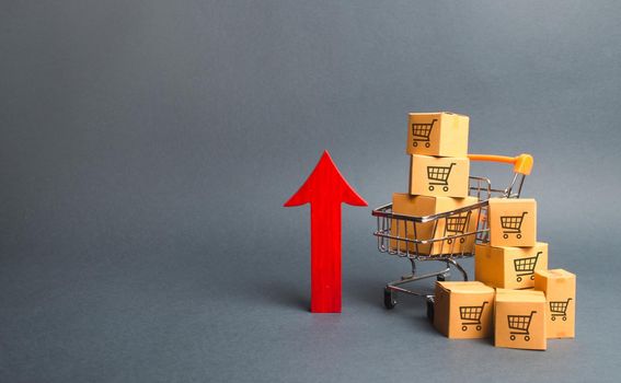 Shopping cart with cardboard boxes with a pattern of trading carts and a red up arrow. Growth wholesale and retail. Improving consumer sentiment, economic growth. Rising prices for goods, inflation