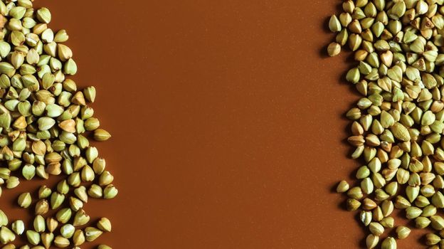 Background from raw organic green buckwheat porridge, vegan food. Texture of scattered buckwheat groats. Seeds are triangular in shape. Organic food. The concept of diet, weight loss, healthy eating