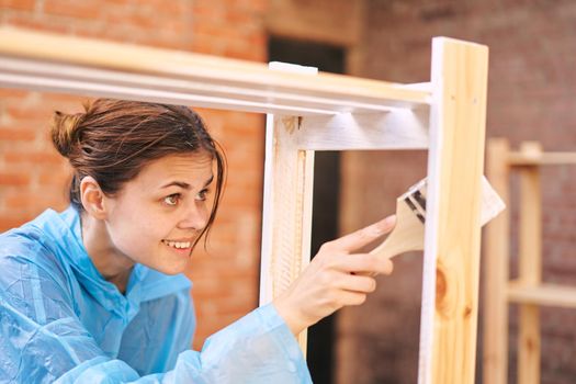 cheerful woman house painter repairing wooden structure. High quality photo