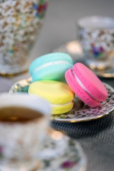 Traditional table with cup of tea and tea pot and colorful macaron lovely cozy table at home,Mother's Day tea setting with teapot, close up