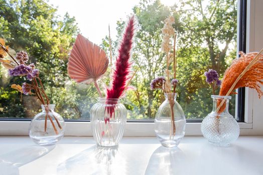 decorative vases and flowers with interior decor concept on window sill,Still life beautiful vase with dried flowers . The concept of comfort and home decor. Close up. Modern style in the interior beauty