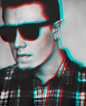 Portrait of handsome young man in sunglasses and plaid shirt. Image with anaglyph effect.