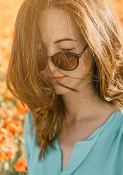 Portrait of smiling beautiful young woman with closed eyes outdoor.