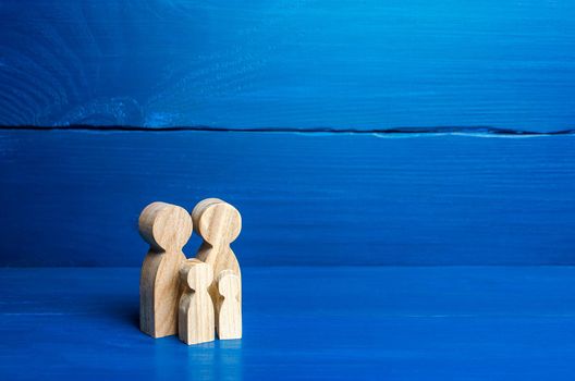 Family figures of parents and kids on a blue background. Family values and health. Adoption and custody of children. Social support, demography, sociology. Upbringing and education. Together concept