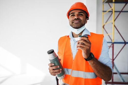 Portrait of a man worker in workwear on a break drink coffee and have rest, close up