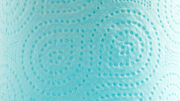Blue roll of modern toilet paper on a blue background. A paper product on a cardboard sleeve, used for sanitary purposes from cellulose with cutouts for easy tearing. Embossed drawing.