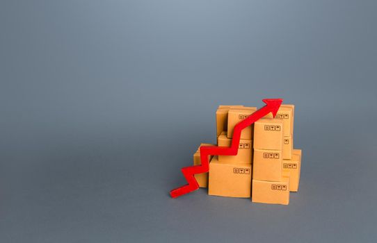 Boxes with goods and a red up arrow. Revenue growth in trade and transportation industry. Rise of the national economy, trade balance. Industrial production increase. Import export. Taxes and duties.