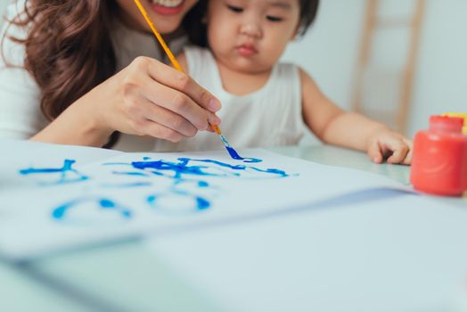 Mother and daughter have a fun painting with watercolor paints