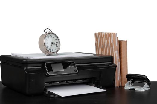 Office table with laser printer and books against white background, close up
