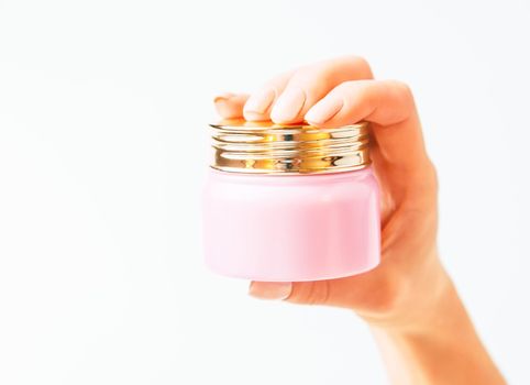 Female hand holding a jar with moisturizing cream on a white background, copy-space.