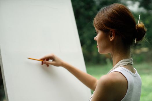 woman outdoors painting a picture creative art landscape. High quality photo