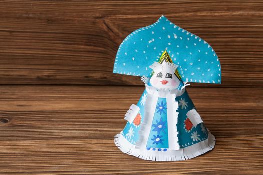 Paper toy Snow Maiden on a wooden background