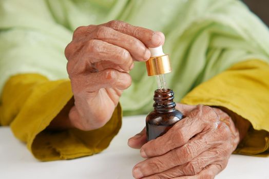 senior women applying essential oils on hand ,