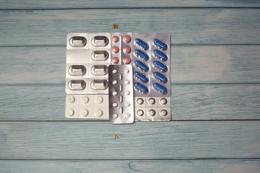Top view of different pills on wooden background, with copy space, pandemic coronavirus protect healthcare concept