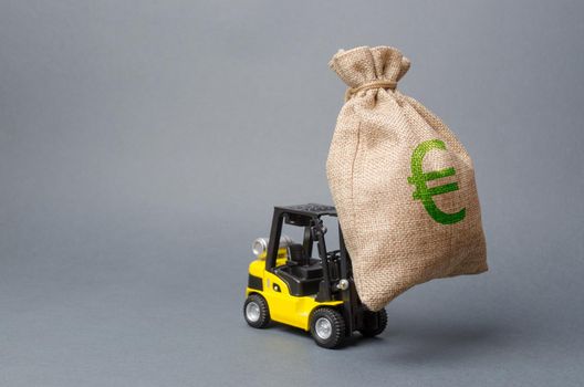 Yellow forklift truck carries a big bag of money. Attracting investment in development, modernization of production and business. Revenue, profit, liquidity. profit point fixation. capital migration