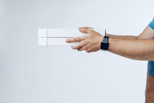 Courier hands giving packed food delivery close up against grey background