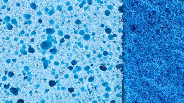 Background in the form of a porous structure in blue. Macro sponge. Close up blue sponge surface for textured background. copy space