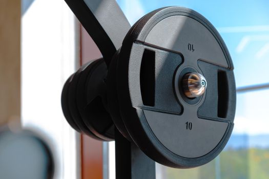 Weight plate on metal barbell in a gym, close up