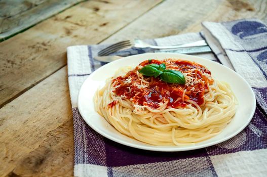 Spaghetti Pasta with Tomato Sauce, Cheese and Basil on Wooden Table. Traditional Italian Food.