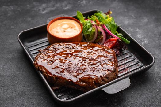 steak with salad and sauce on a blackboard