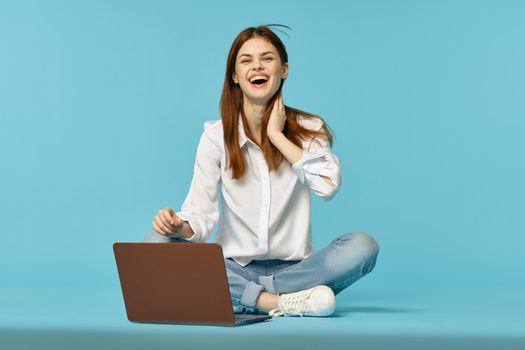 woman with laptop learning internet online education blue background. High quality photo