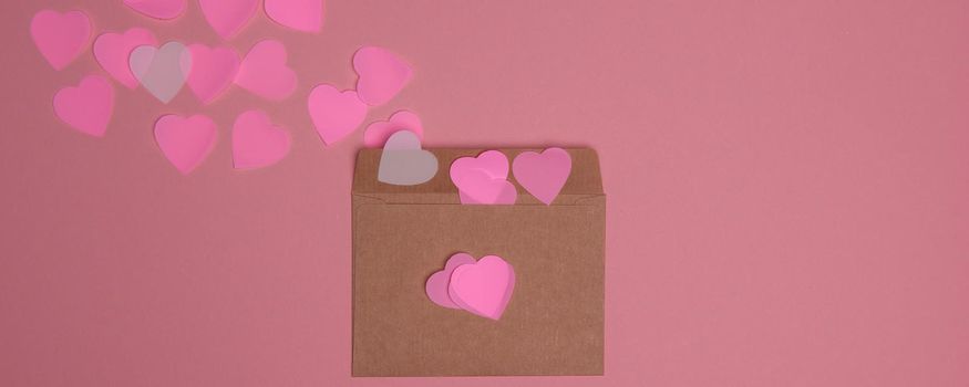 Valentine day composition with copy space. Confetti, envelope postcard with pink and white hearts on pastel background. Close up, top view, copy space