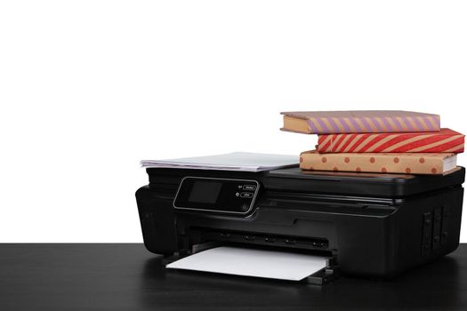 Working table with printer and stacked books on white abckground, close up