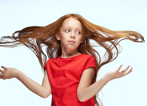 girl with red hair posing red t-shirt childhood. High quality photo