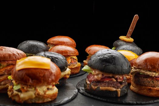 Many different burgers on dark, shallow depth of field