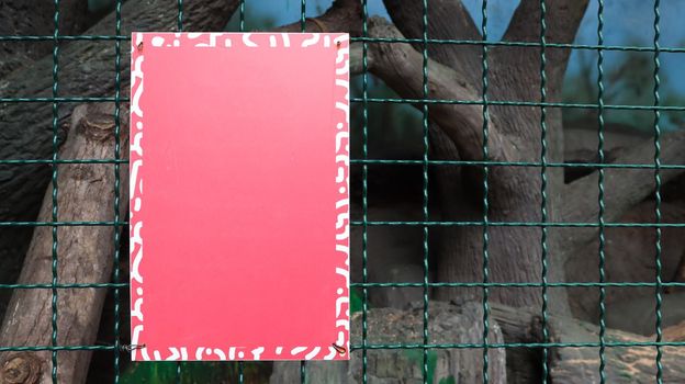 Red blank metallic signboard on a fence for artwork template design. blank form. Copy space for your text or logo