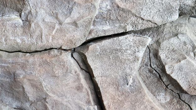 Stone rock texture or background. Gray rocky uneven surface, natural seamless backdrop for design. Copy space.