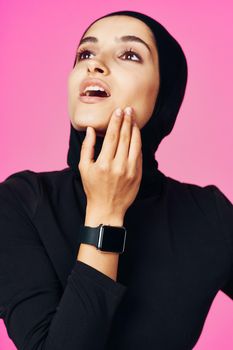 muslim woman with smart watch technology gadget pink background. High quality photo