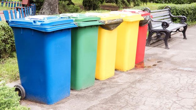Separate containers for garbage collection in the park. Multi-colored street trash cans on the street. Containers Selective collection of waste. Environmental pollution concept