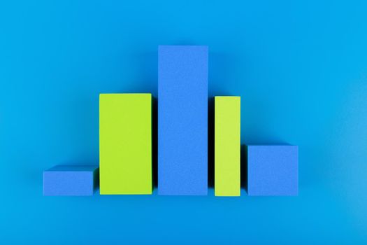 Business concept. Blue and green graph diagram or performance chart with rise and fall dynamic against blue background with copy space. Chart for marketing, annual or corporate report or profit growing