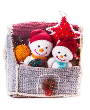 Two knitted christmas snowmen in a house and handmade christmas tree