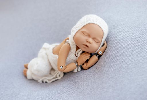 Doll mannequin of newborn baby for posing training photographer practice. Concept of infant cute photosession