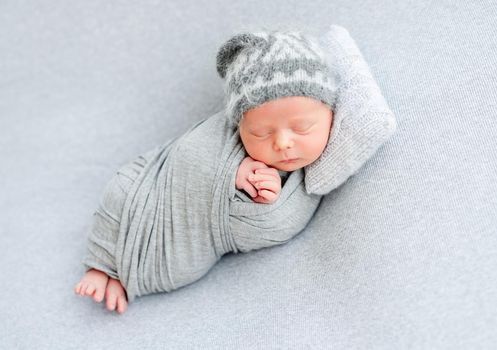 Cute newborn sleeping on tiny pillow lying on side