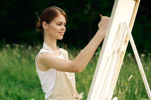 woman artist paints a picture on nature art hobby. High quality photo